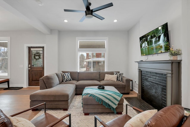 living room with a wealth of natural light, ceiling fan, and light wood-type flooring