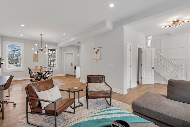 living room featuring a chandelier and light hardwood / wood-style floors