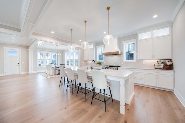 kitchen with white cabinets, hanging light fixtures, and ornamental molding