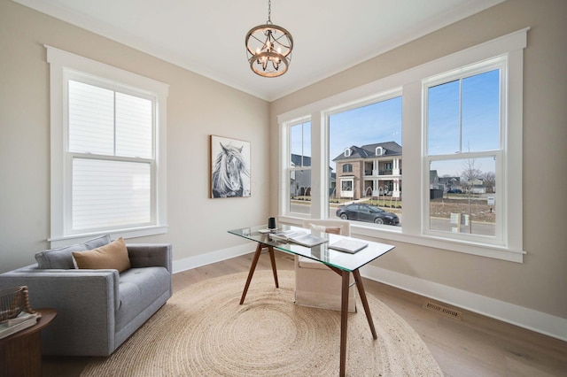 office space featuring wood-type flooring, crown molding, and a chandelier