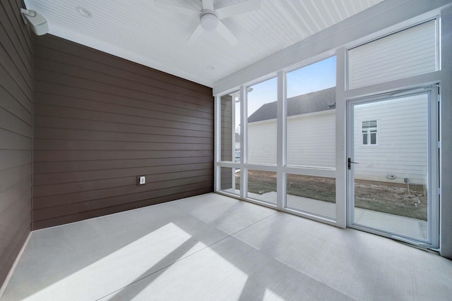 unfurnished sunroom featuring ceiling fan