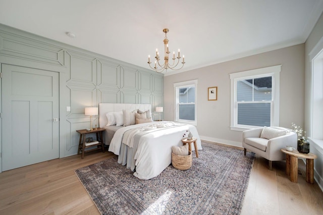 bedroom featuring hardwood / wood-style flooring, ornamental molding, and a notable chandelier