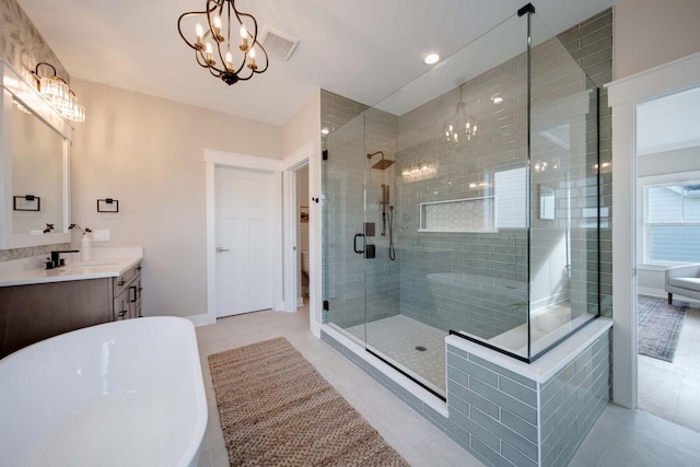 bathroom with tile patterned flooring, shower with separate bathtub, vanity, and a notable chandelier