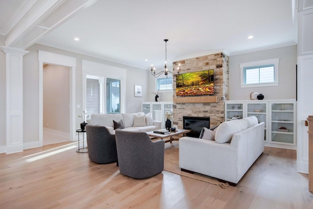 living room featuring a wealth of natural light, a fireplace, light hardwood / wood-style floors, and ornamental molding