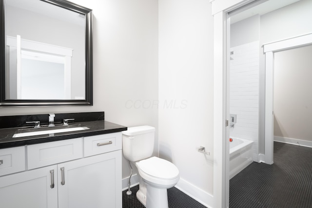 full bathroom featuring vanity, tiled shower / bath, and toilet