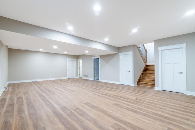 basement with light hardwood / wood-style flooring