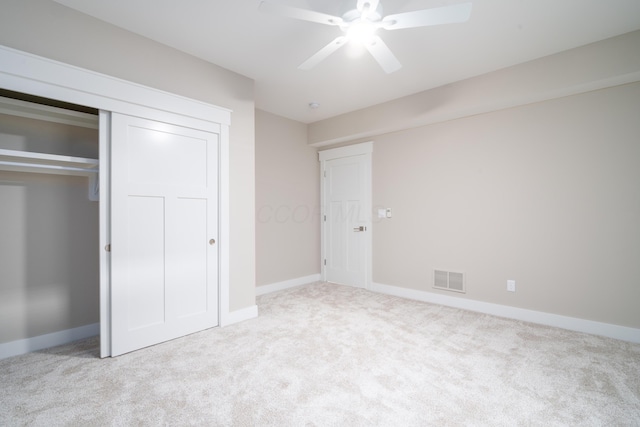 unfurnished bedroom with ceiling fan, light colored carpet, and a closet