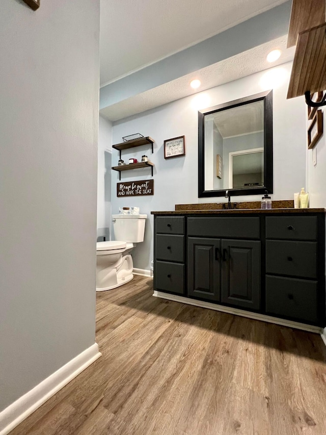 bathroom with hardwood / wood-style floors, vanity, and toilet