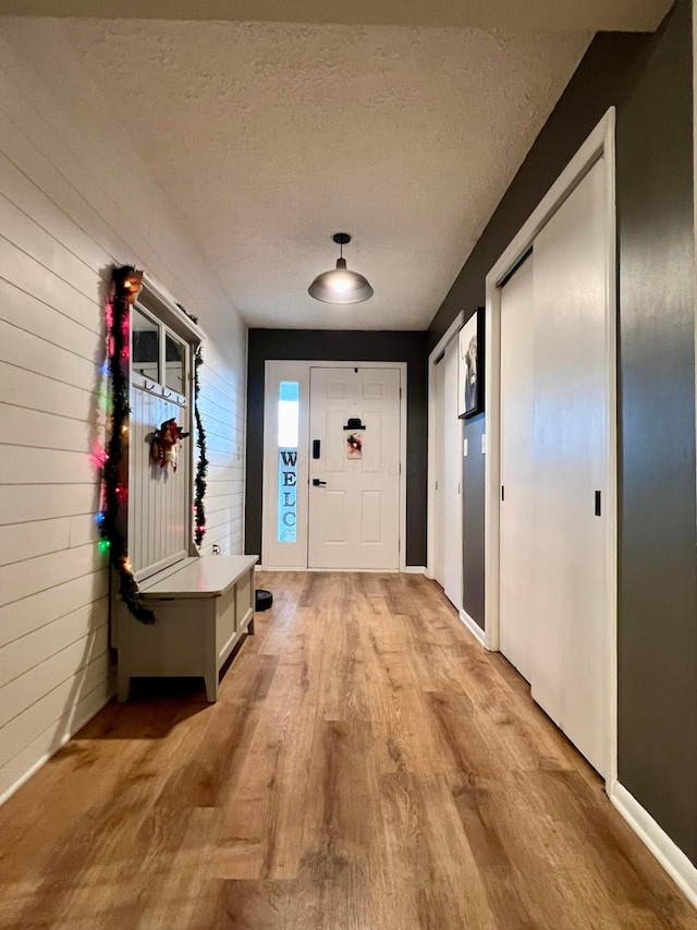 entryway featuring a textured ceiling and light hardwood / wood-style flooring