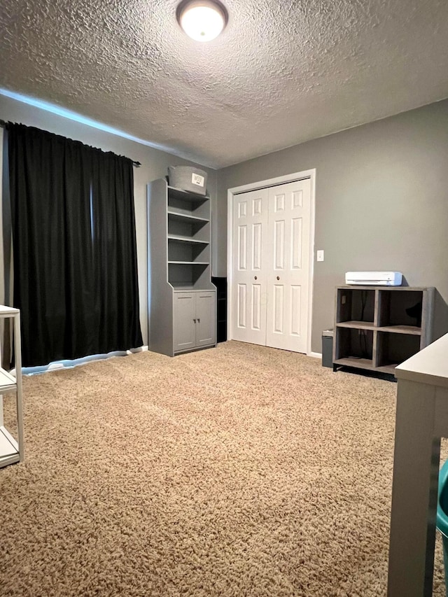 unfurnished bedroom with carpet flooring, a textured ceiling, and a closet