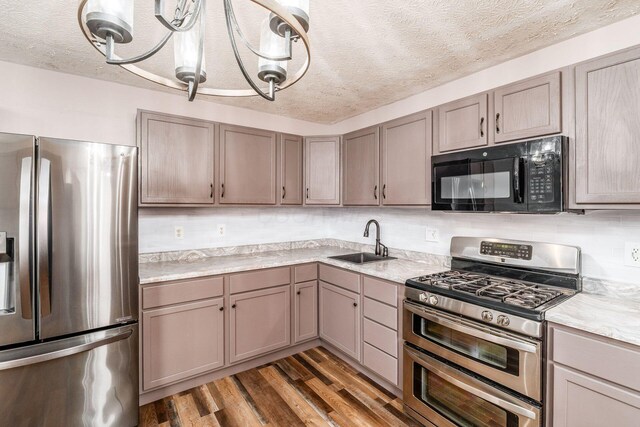 kitchen with sink, dark wood-type flooring, a textured ceiling, and appliances with stainless steel finishes