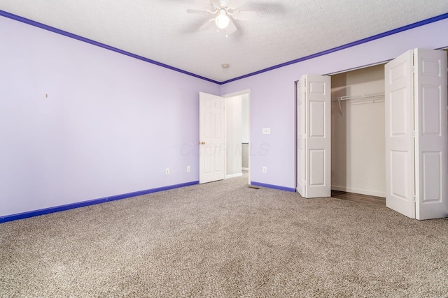 unfurnished bedroom featuring carpet flooring, ornamental molding, a textured ceiling, ceiling fan, and a closet