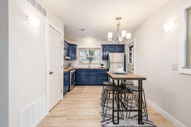 kitchen featuring sink, appliances with stainless steel finishes, light hardwood / wood-style floors, and blue cabinets