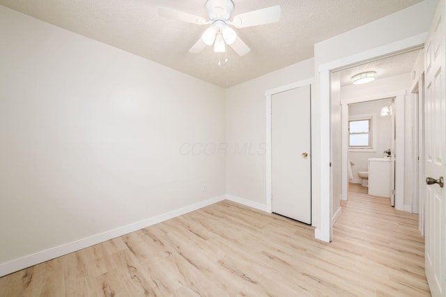 unfurnished room with a textured ceiling, light hardwood / wood-style flooring, and ceiling fan