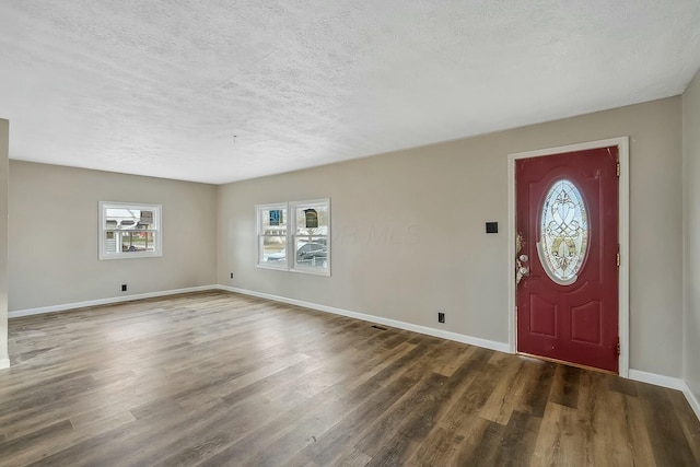 entryway with dark wood-type flooring and a textured ceiling