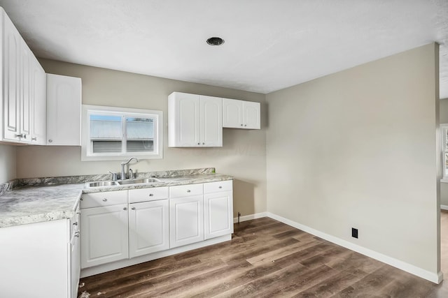 kitchen featuring dark hardwood / wood-style flooring, white cabinets, and sink