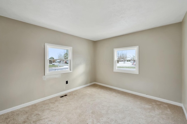 unfurnished room featuring light colored carpet