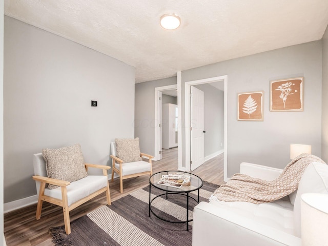 living area featuring a textured ceiling and hardwood / wood-style flooring