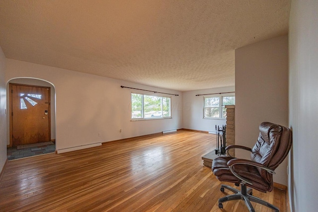 sitting room with wood-type flooring, a textured ceiling, and a baseboard radiator