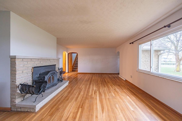 living room with a wood stove, hardwood / wood-style floors, and a textured ceiling