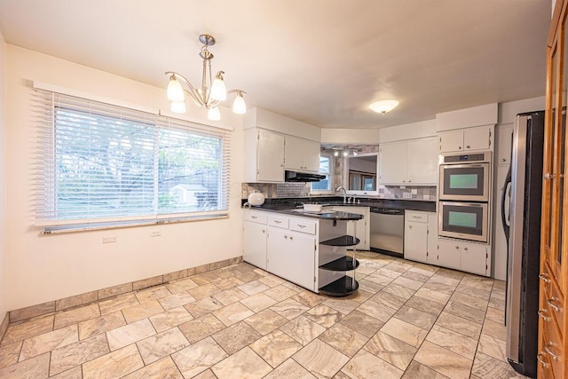 kitchen with decorative backsplash, white cabinetry, stainless steel appliances, and decorative light fixtures