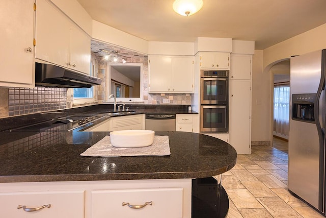 kitchen featuring white cabinets, sink, decorative backsplash, appliances with stainless steel finishes, and kitchen peninsula