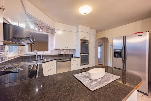 kitchen featuring white cabinetry, sink, wall chimney range hood, decorative backsplash, and appliances with stainless steel finishes