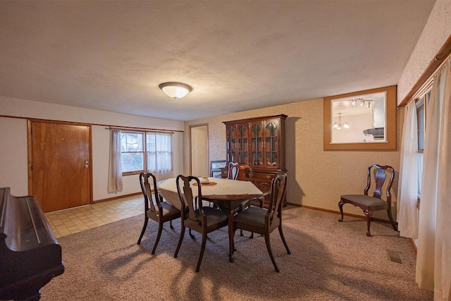 dining area featuring a textured ceiling and light carpet