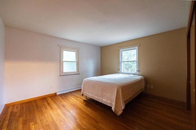 bedroom featuring hardwood / wood-style floors and baseboard heating