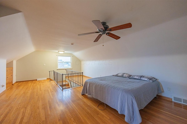 bedroom with ceiling fan, hardwood / wood-style floors, and vaulted ceiling