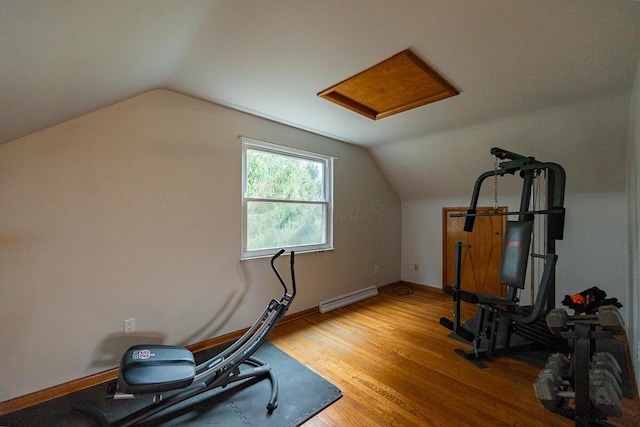 exercise room featuring wood-type flooring, baseboard heating, and lofted ceiling