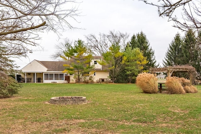 view of yard featuring a sunroom, a fire pit, and a pergola