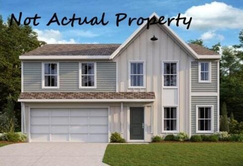 view of front of property featuring a garage and a front lawn