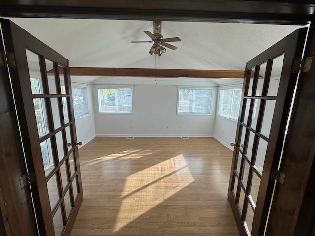 spare room featuring ceiling fan, vaulted ceiling, light hardwood / wood-style flooring, and french doors