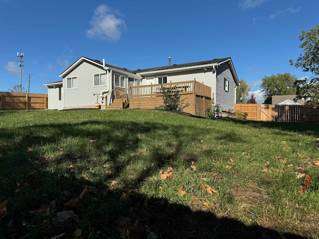 back of property with a lawn and a deck