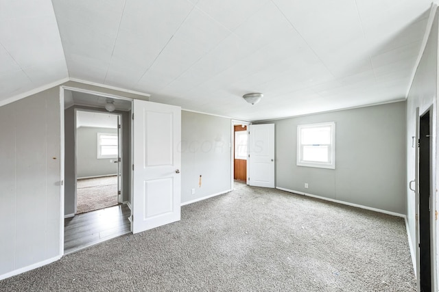 unfurnished bedroom featuring carpet flooring and vaulted ceiling