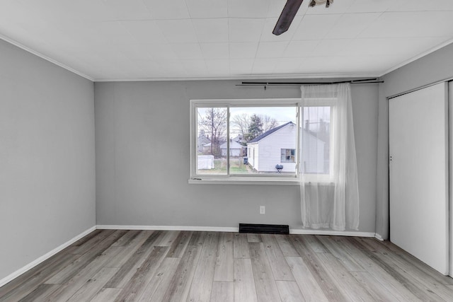 unfurnished room featuring light wood-type flooring and ornamental molding