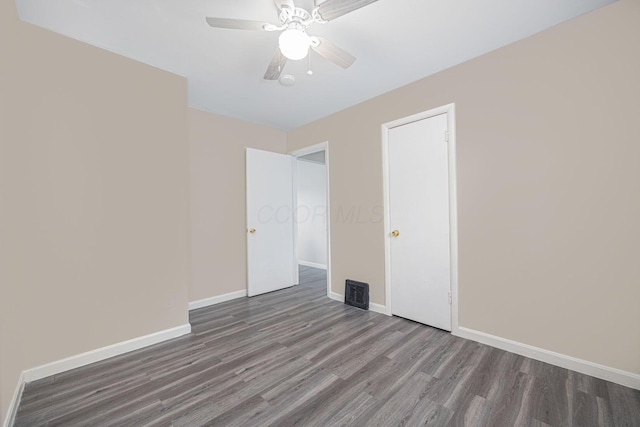 unfurnished room with dark hardwood / wood-style floors and ceiling fan