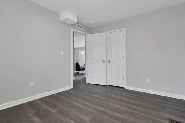 unfurnished bedroom with dark hardwood / wood-style floors