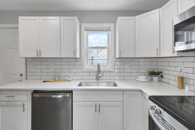 kitchen featuring decorative backsplash, white cabinetry, sink, and stainless steel appliances