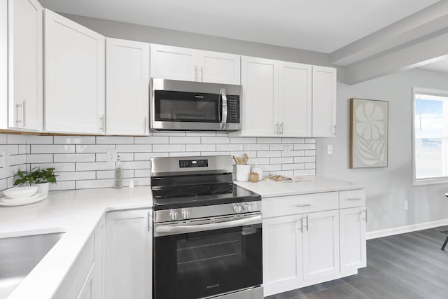 kitchen featuring dark hardwood / wood-style flooring, backsplash, stainless steel appliances, and white cabinetry