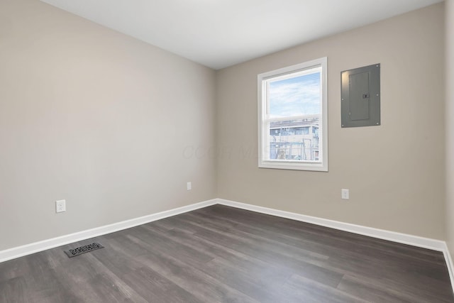 unfurnished room featuring electric panel and dark wood-type flooring