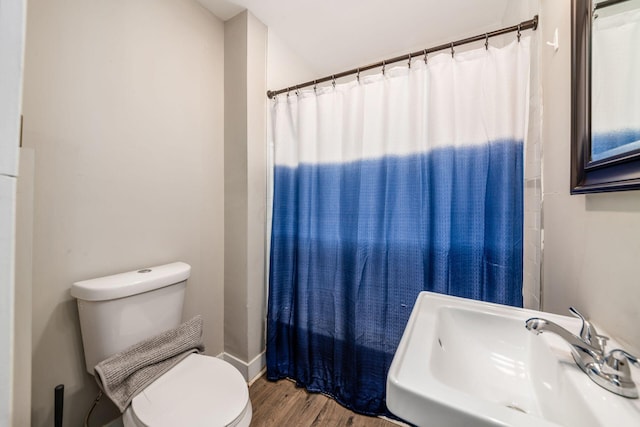 bathroom featuring sink, a shower with shower curtain, hardwood / wood-style floors, and toilet