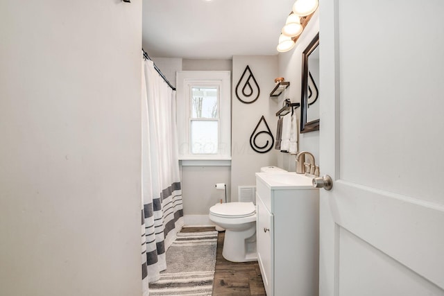 bathroom with hardwood / wood-style floors, vanity, and toilet