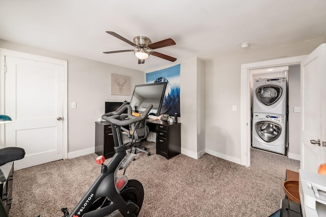 carpeted home office with ceiling fan and stacked washer / drying machine