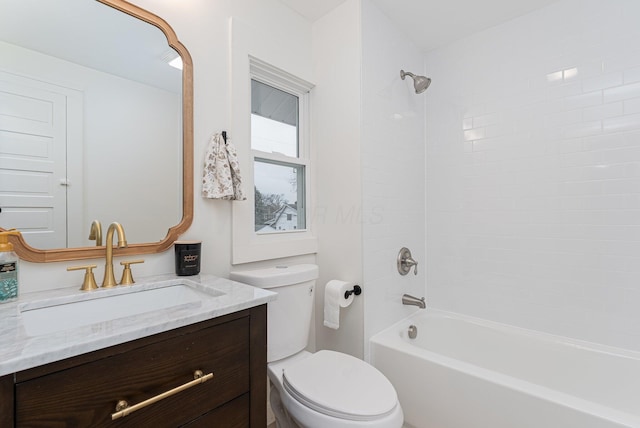 full bathroom featuring vanity, tiled shower / bath combo, and toilet