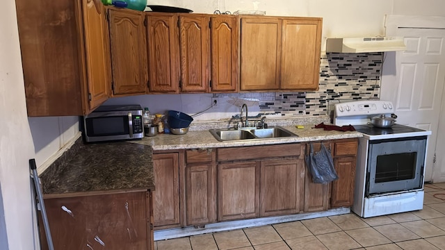 kitchen with electric stove, sink, decorative backsplash, and light tile patterned floors