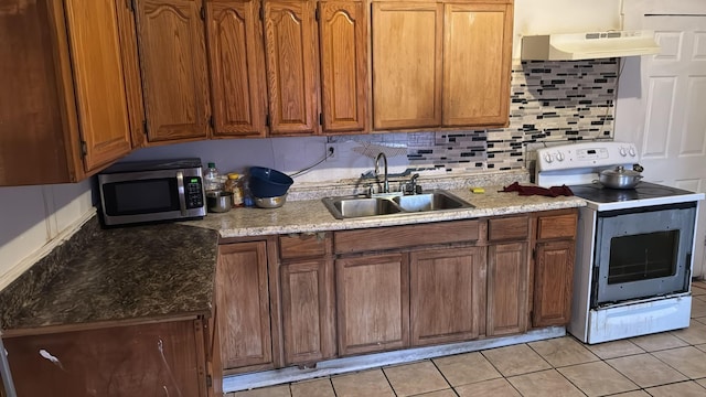 kitchen with tasteful backsplash, white electric range oven, sink, and light tile patterned floors