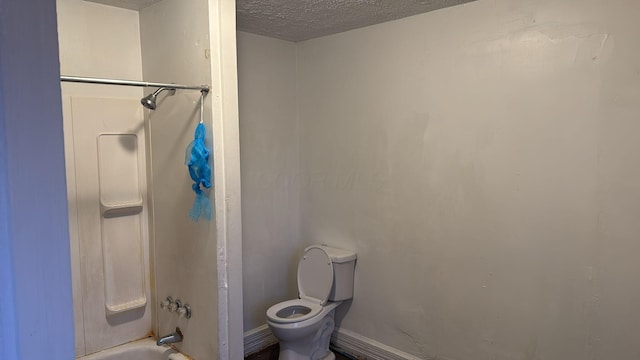 bathroom with a textured ceiling, shower / bathtub combination, and toilet