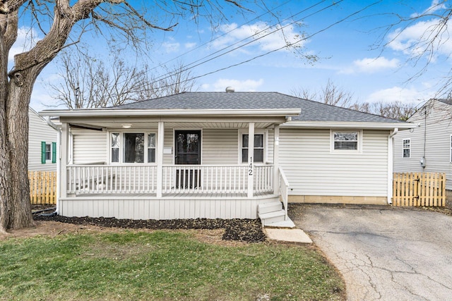 ranch-style home with covered porch and a front lawn